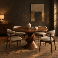 Round dining table with a twisted sculpted pedestal base in a dark dining room at golden hour