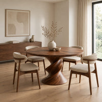 Round dining table with a twisted sculpted pedestal base in a Scandinavian dining room with white walls