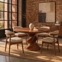Round dining table with a twisted sculpted pedestal base in an industrial loft dining room with exposed brick
