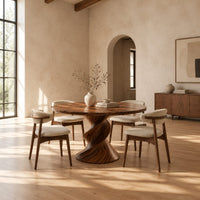 Round dining table with a twisted sculpted pedestal base in a bright open plan dining room