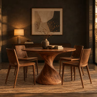 Round dining table on a twisted spiral pedestal in a dark dining room at golden hour