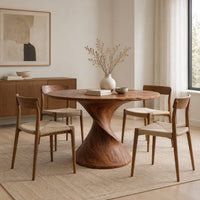 Round dining table on a twisted spiral pedestal in a Scandinavian dining room with white walls