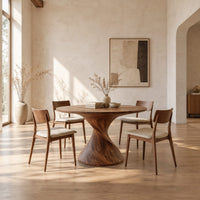 Round dining table on a twisted spiral pedestal in a bright open plan dining room