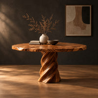 Round dining table with a twisted spiral pedestal base in a dark studio against a charcoal plaster wall