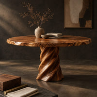Corner detail of round dining table with a twisted spiral pedestal base beside wood, brass and linen samples