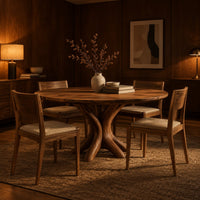 Circular dining table with a pedestal of twisting branch shaped limbs in an evening dining room with walnut wall paneling