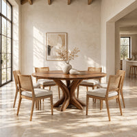 Circular dining table with a pedestal of twisting branch shaped limbs in a bright open plan dining room