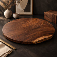 Corner detail of circular wood table top with swirling grain and one natural edge beside wood, brass and linen samples
