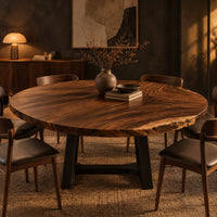 Circular wood table top with swirling grain and one natural edge in a dark dining room at golden hour