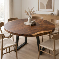 Circular wood table top with swirling grain and one natural edge in a Scandinavian dining room with white walls
