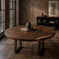 Circular wood table top with swirling grain and one natural edge in an industrial loft dining room with exposed brick