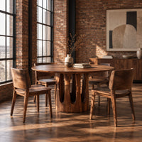 Round pedestal dining table with tall arched slots in the base in an industrial loft dining room with exposed brick
