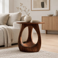 Round side table with an open teardrop pedestal and a flared foot in a Scandinavian living room with white walls