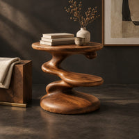 Corner detail of circular side table with a spiral stem, middle shelf disc and wide base beside wood, brass and linen samples