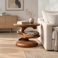 Circular side table with a spiral stem, middle shelf disc and wide base in a Scandinavian living room with white walls