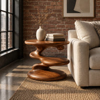 Circular side table with a spiral stem, middle shelf disc and wide base in an industrial loft living room with exposed brick