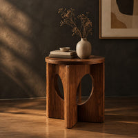 Round side table with a panel base and tall oval cutouts, three-quarter view showing the grain