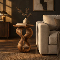 Round wood side table on a twisted figure eight pedestal in a dark living room at golden hour