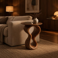 Round wood side table on a twisted figure eight pedestal in an evening living room with walnut wall paneling