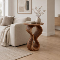Round wood side table on a twisted figure eight pedestal in a Scandinavian living room with white walls