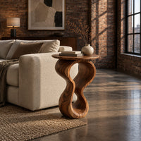Round wood side table on a twisted figure eight pedestal in an industrial loft living room with exposed brick