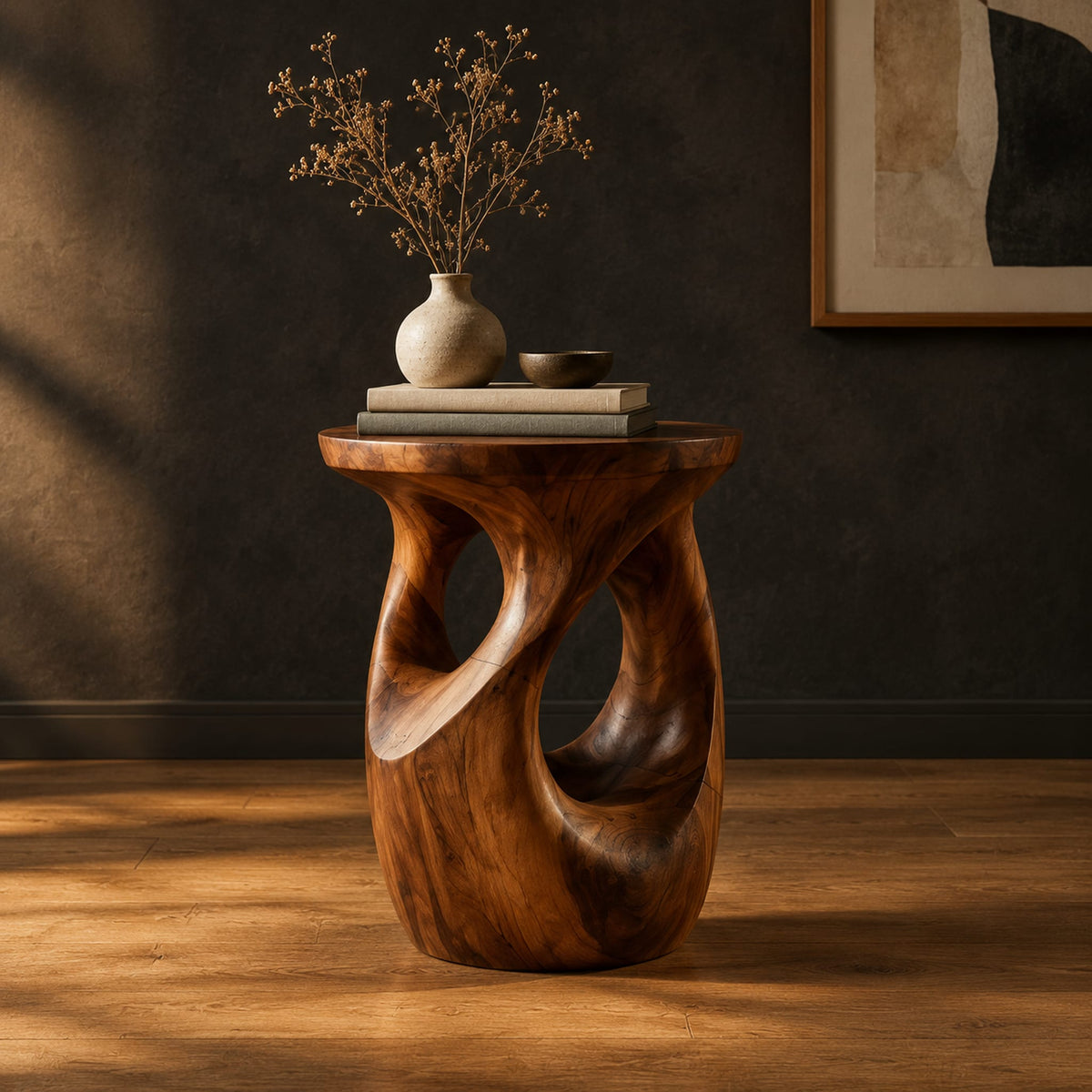 Round side table with a vase shaped base and twisting cutouts in a dark studio against a charcoal plaster wall