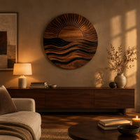 Round wall art of a sun setting over layered waves above a low console in an evening living room