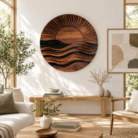 Round wall art of a sun setting over layered waves in a bright sunroom with green plants