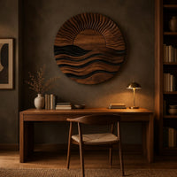 Round wall art of a sun setting over layered waves above a desk in a dark study corner