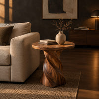 Side table with a circular top on a twisted spiral pedestal in a dark living room at golden hour