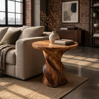 Side table with a circular top on a twisted spiral pedestal in an industrial loft living room with exposed brick