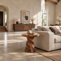 Side table with a circular top on a twisted spiral pedestal in a bright open plan living room