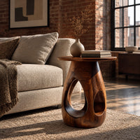 Round side table with teardrop cutouts in a pear shaped pedestal in an industrial loft living room with exposed brick