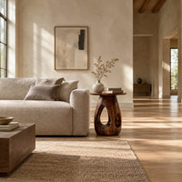 Round side table with teardrop cutouts in a pear shaped pedestal in a bright open plan living room