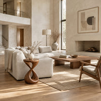 Side table with a circular top and a twisted figure eight pedestal base in a bright open plan living room