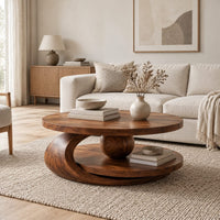 Round two tier coffee table with a wooden sphere and crescent shaped support in a Scandinavian living room with white walls