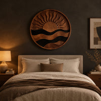 Circular carved sun and wave wall art with dark and natural wood bands above a bed in a dusk lit bedroom