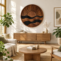 Circular carved sun and wave wall art with dark and natural wood bands in a bright sunroom with green plants