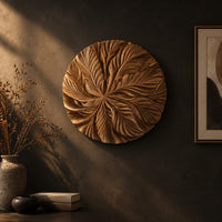Circular wood disc carved with overlapping leaves that radiate from the center on a dark charcoal plaster wall