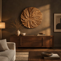 Circular wood disc carved with overlapping leaves that radiate from the center above a low console in an evening living room