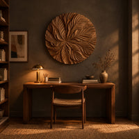 Circular wood disc carved with overlapping leaves that radiate from the center above a desk in a dark study corner