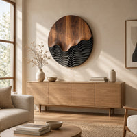 Circular wood wall art with smooth grain above dark carved wave ridges above a light oak sideboard in daylight