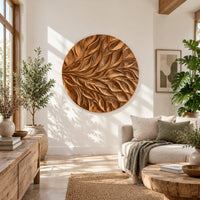 Circular wall art panel carved with sweeping layered leaves in a bright sunroom with green plants