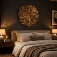 Round wood wall art with swirling carved petals in relief above a bed in a dusk lit bedroom