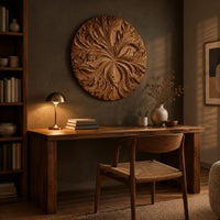 Round wood wall art with swirling carved petals in relief above a desk in a dark study corner