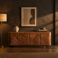 Rounded sideboard with carved waves and circle motifs in a dark dining room at golden hour