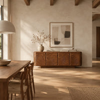 Rounded sideboard with carved waves and circle motifs in a bright open plan dining room