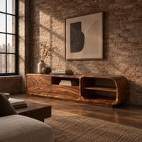 Low rounded tv stand with three drawers and open shelves in an industrial loft living room with exposed brick