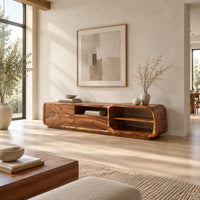 Low rounded tv stand with three drawers and open shelves in a bright open plan living room