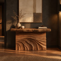Console table with rough slab top and dune carved base in a dark entryway at golden hour